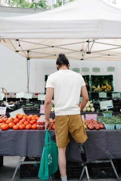 Disabilities in Israel - man with amputated leg shopping for produce 